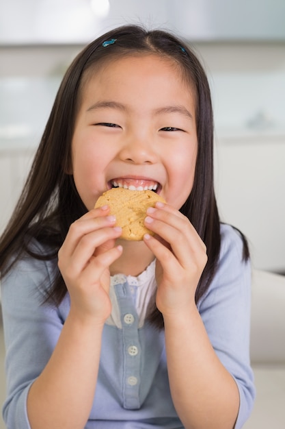 Ritratto di una ragazza sorridente che gode dei biscotti