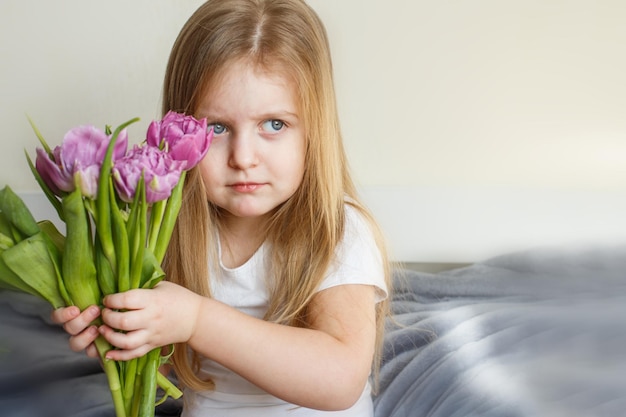 Ritratto di una ragazza sorridente felice con bouquet di fiori tulipani nelle sue mani