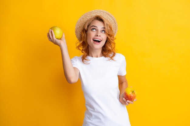 Ritratto di una ragazza sorridente felice con mela isolato su sfondo giallo