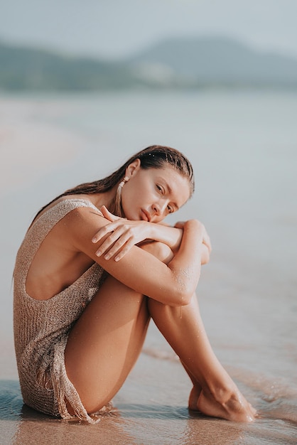 Ritratto di una ragazza sorridente seduta sulla spiaggia