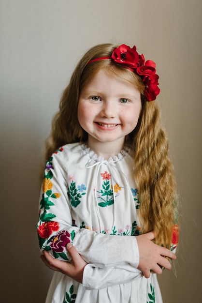 Ritratto di una ragazza vestita con un abito ricamato popolare ucraino Un bambino con una corona di papaveri in testa Costume o abito tradizionale etnico nazionale Ragazza ucraina Tradizioni doganali ucraine
