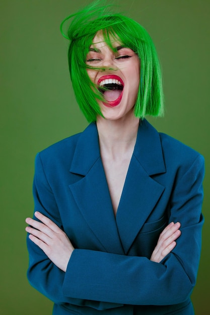 Ritratto di una signora affascinante che indossa una giacca blu parrucca verde in posa sfondo verde inalterato