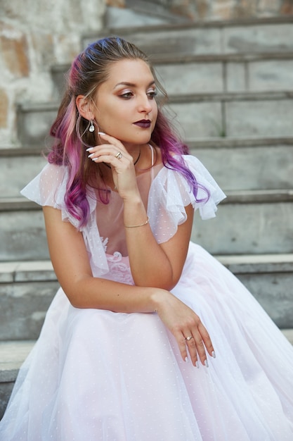 Ritratto di una sposa con il primo piano capelli viola. Una donna in un bel vestito sta riposando