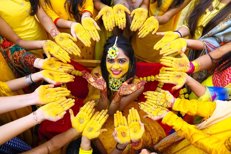 Foto ritratto di una sposa sorridente tra le donne durante la cerimonia di haldi