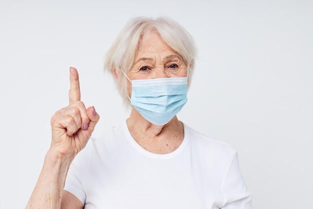 Ritratto di una vecchia donna amichevole salute stile di vita medica maschera trattamento sfondo chiaro