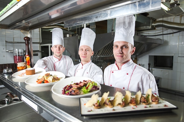 Ritratto di uno chef con cibi cotti in cucina nel ristorante.