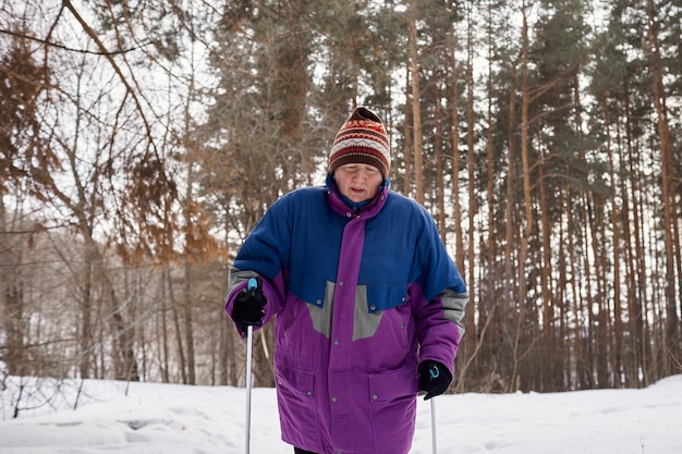 Ritratto di uno sciatore anziano in una foresta invernale