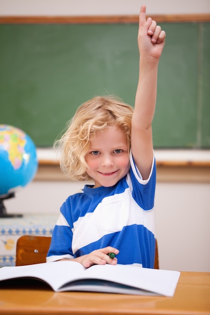 Ritratto di uno scolaro che alza la mano