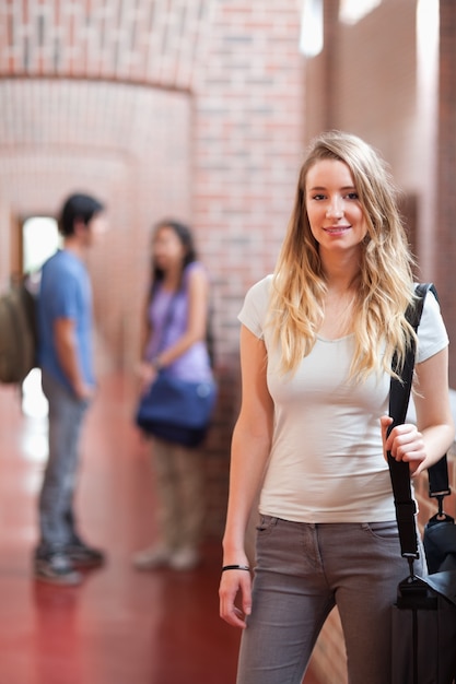 Ritratto di uno studente in posa mentre i suoi amici stanno parlando