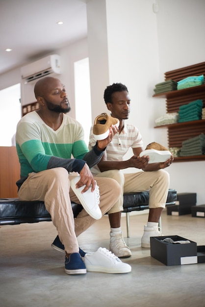 Ritratto di uomini gay afroamericani che tengono le scarpe