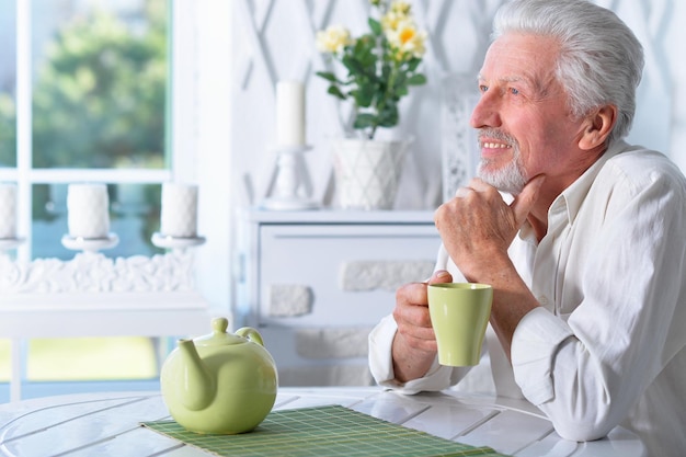 Ritratto di uomo anziano che beve il tè a casa