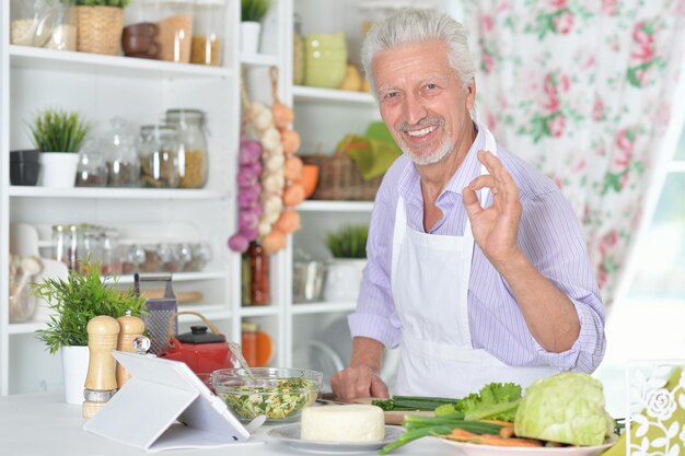 Ritratto di uomo anziano che prepara la cena in cucina