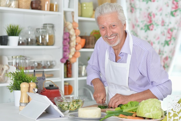 Ritratto di uomo anziano che prepara la cena in cucina