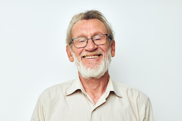 Ritratto di uomo anziano felice con una barba grigia in una camicia e occhiali sfondo isolato