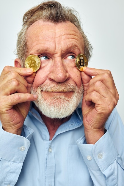 Ritratto di uomo anziano felice in una camicia blu bitcoin sul viso vista ritagliata