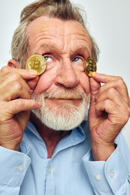 Ritratto di uomo anziano felice in una camicia blu bitcoin sul viso vista ritagliata