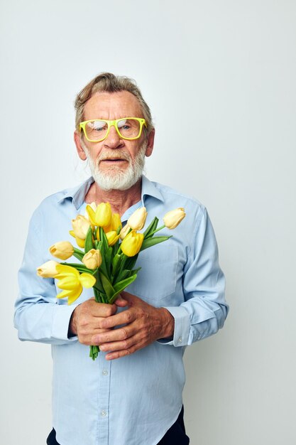 Ritratto di uomo anziano felice un mazzo di fiori con gli occhiali come regalo inalterato