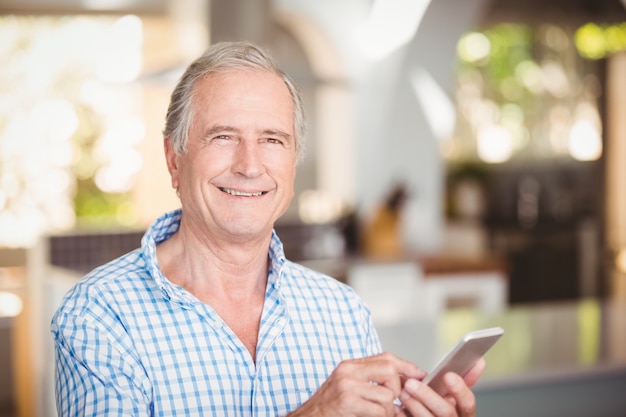 Ritratto di uomo anziano felice utilizzando il telefono cellulare