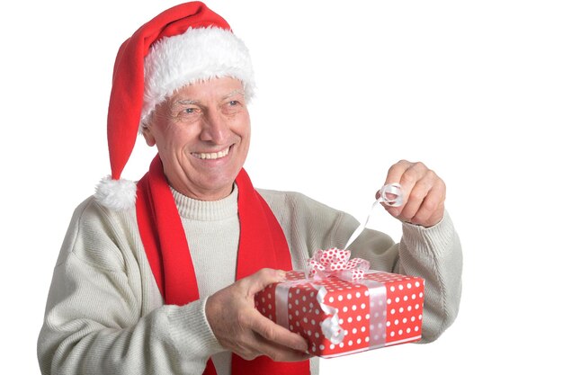 Ritratto di uomo anziano in cappello da Babbo Natale con regalo isolato su sfondo bianco