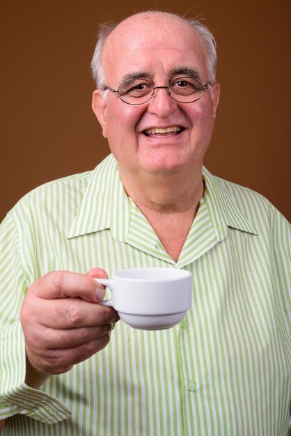 Ritratto di uomo anziano in sovrappeso con tazza di caffè