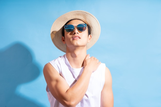 Ritratto di uomo asiatico bello che indossa occhiali da sole, concetto di vacanza estiva