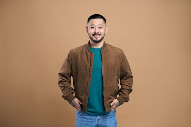 Ritratto di uomo barbuto coreano in posa con la faccia felice che guarda l'obbiettivo