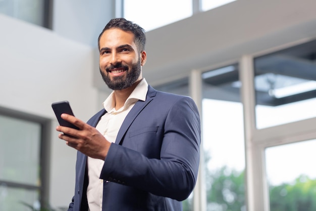 Ritratto di uomo bello che tiene il suo telefono