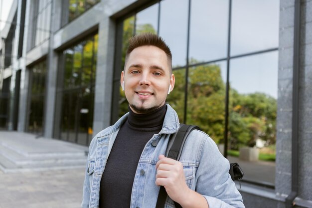 Ritratto di uomo bello con le cuffie nelle orecchie all'aperto