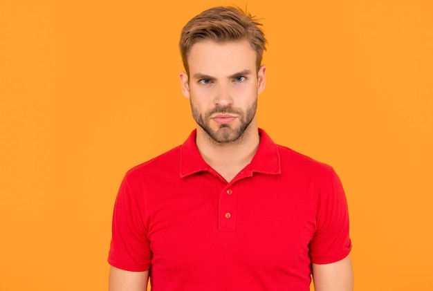 ritratto di uomo con setole in camicia rossa giovane uomo serio con barba su sfondo giallo capelli e cura della barba bel tizio non rasato maschio moda casuale bellezza maschile