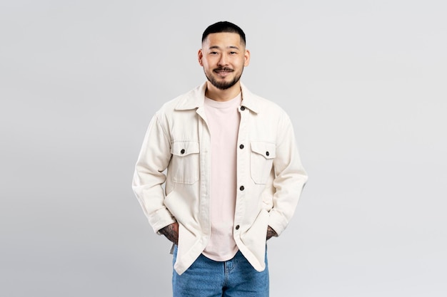 Ritratto di uomo d'affari asiatico di successo che indossa abiti casual moderni isolati su sfondo grigio