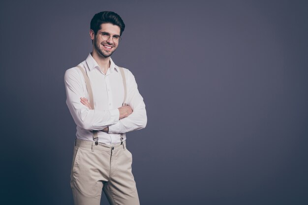 ritratto di uomo d'affari bello mani incrociate toothy raggiante sorridente capo vestito formalwear camicia bianca bretelle beige pantaloni specifiche.