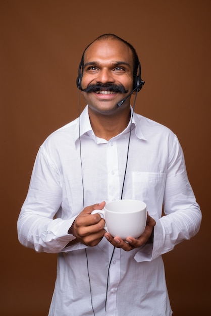 Ritratto di uomo d'affari indiano felice con i baffi come rappresentante del call center