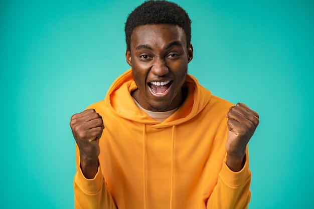 Ritratto di uomo di colore felicissimo che celebra il successo in studio