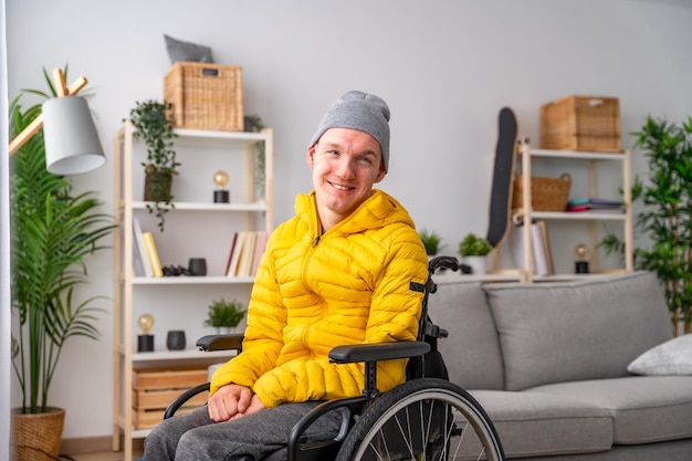 Ritratto di uomo disabile sorridente in sedia a rotelle a casa