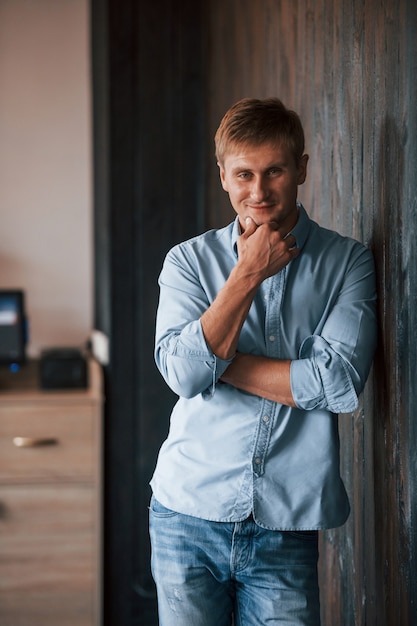 Ritratto di uomo in camicia ufficiale che posa per la macchina fotografica al chiuso.