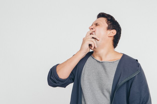 Ritratto di uomo pensieroso. Ragazzo con le mani sul viso isolato su sfondo bianco