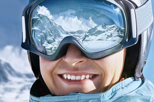 Ritratto di uomo presso la stazione sciistica sullo sfondo di montagne e cielo blu