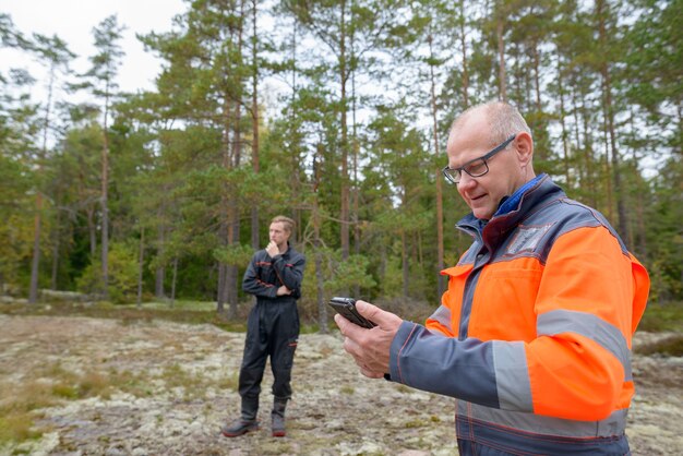 Ritratto di uomo scandinavo maturo e giovane uomo scandinavo pronto per la raccolta nella foresta insieme all'aperto