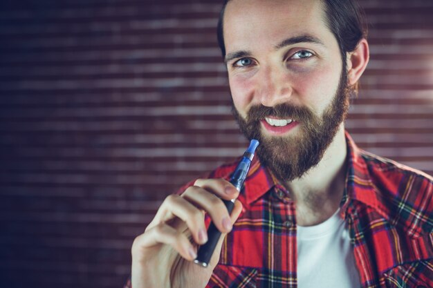 Ritratto di uomo sorridente con sigaretta elettronica