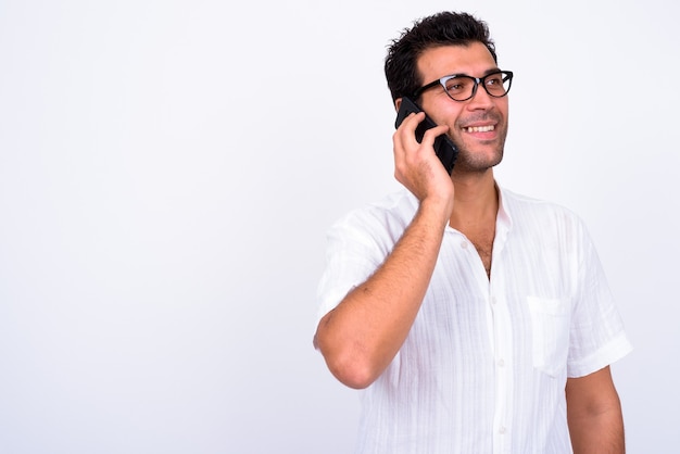 Ritratto di uomo turco bello felice pensando mentre si parla al telefono