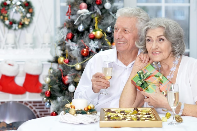 Ritratto di vecchia coppia che celebra il Natale con champagne