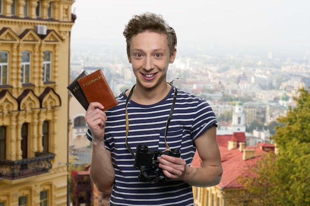 Ritratto di viaggiatore americano adolescente in Europa. Ragazzo con passaporto e binocolo.