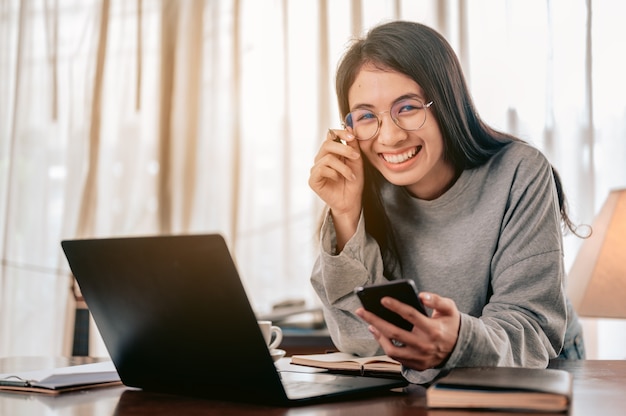 Ritratto Donna felice che lavora da casaUsa la risposta in chat dello smartphone per il cliente