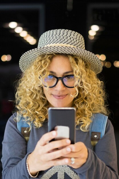 ritratto e primo piano di una bella donna ricciola e bionda che guarda la telecamera sorridendo persone felici che viaggiano all'aeroporto vacanze all'aperto