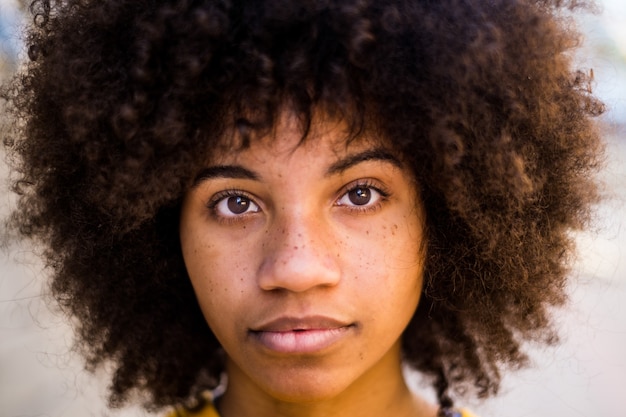 Ritratto e primo piano di una bellissima giovane donna africana o americana che guarda la telecamera