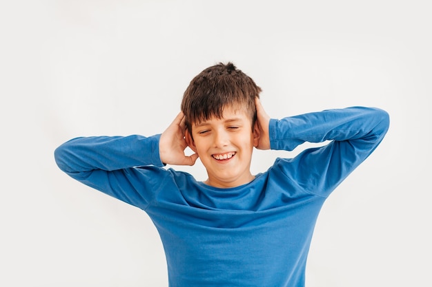 Ritratto emotivo a mezzo busto di ragazzo adolescente caucasico che indossa t-shirt blu. Adolescente sorpreso che guarda l'obbiettivo. Bel bambino felice, isolato su sfondo bianco.