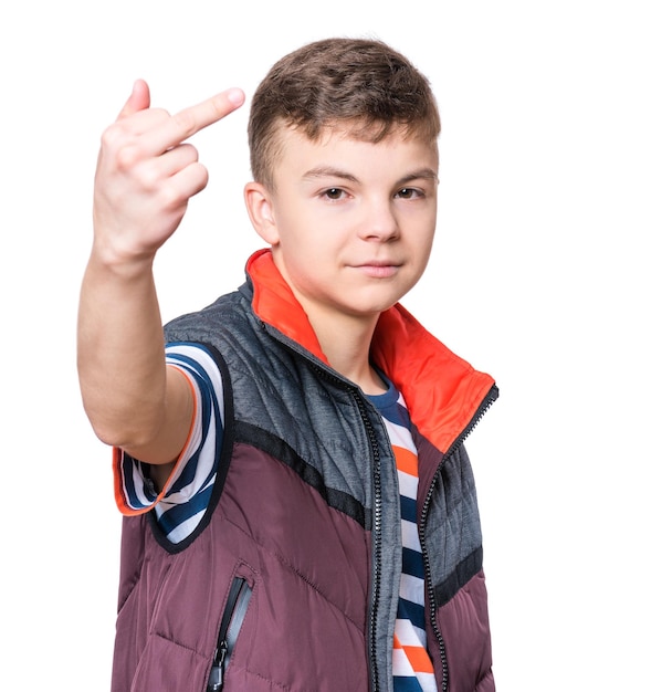 Ritratto emotivo di un adolescente irritato isolato su uno sfondo bianco un adolescente furioso che guarda con rabbia la telecamera e mostra il dito medio o il segnale fottuto