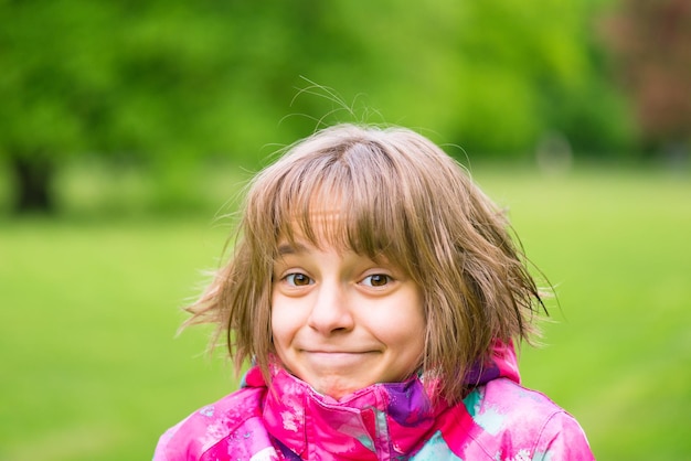 Ritratto emotivo di una attraente studentessa caucasica con bellissimi occhi marroni nel parco della città di Spring Un bambino sorridente e carino che guarda la telecamera da vicino all'aperto