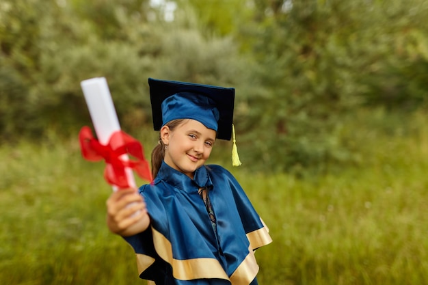 Ritratto emotivo di una piccola studentessa felice laureata