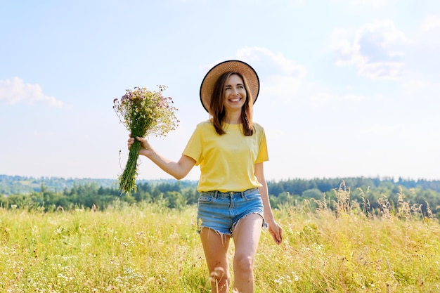 Ritratto estivo di donna felice anni '30 con bouquet di fiori di campo